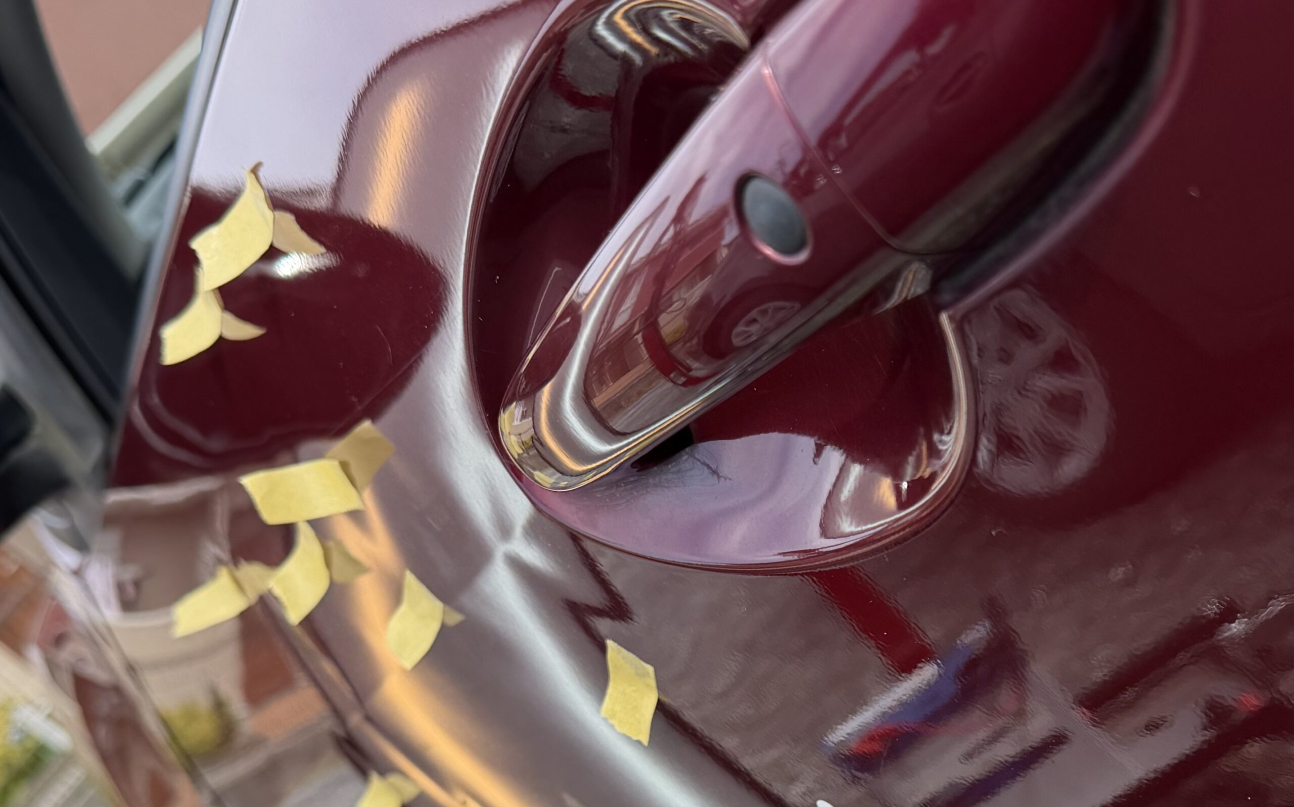 ドアパネルに11箇所以上の凹み マスキングテープで位置をマークした修理前の写真