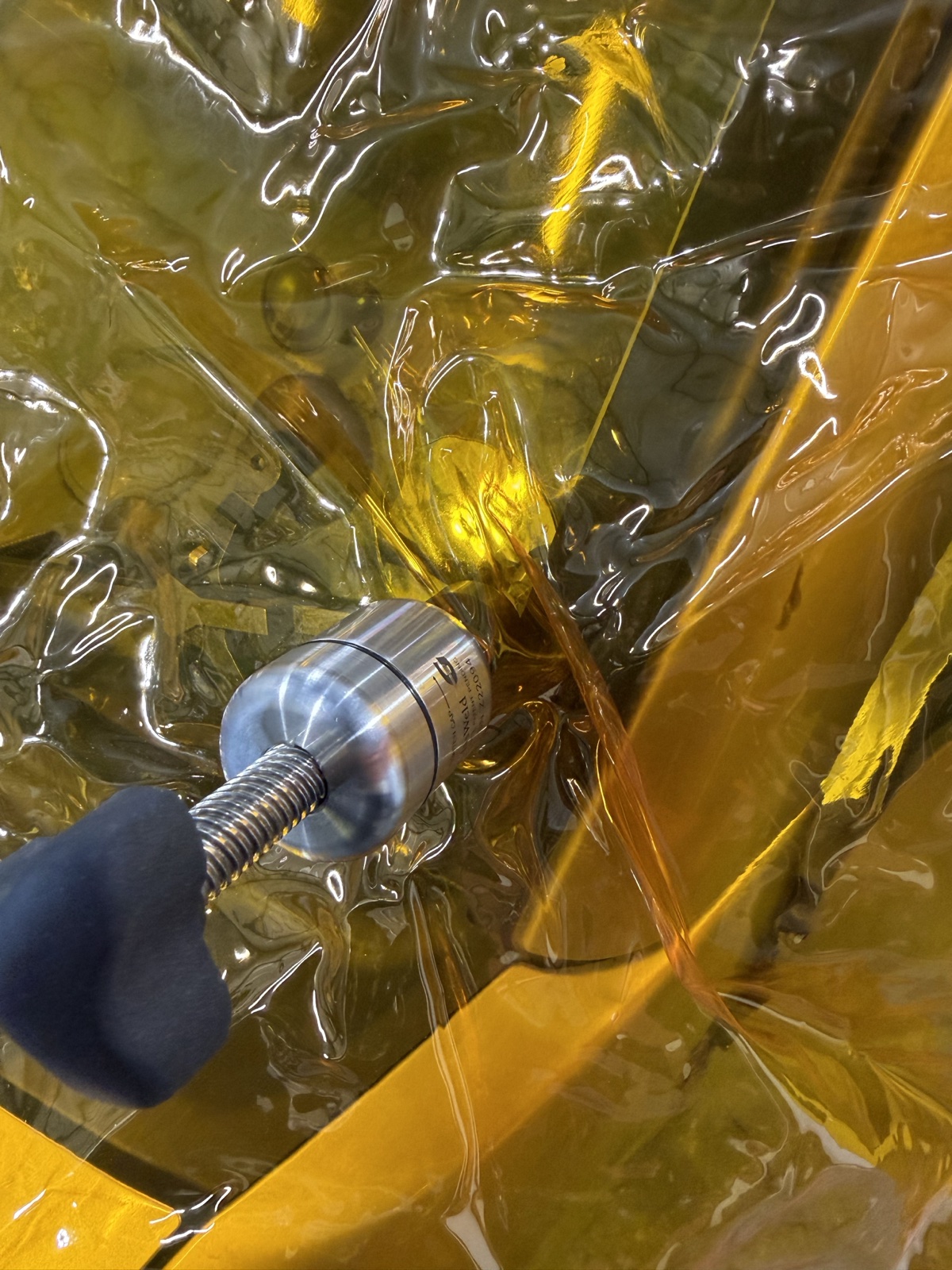 紫外線カットの特殊フィルムで保護しながら真空引き中の作業風景