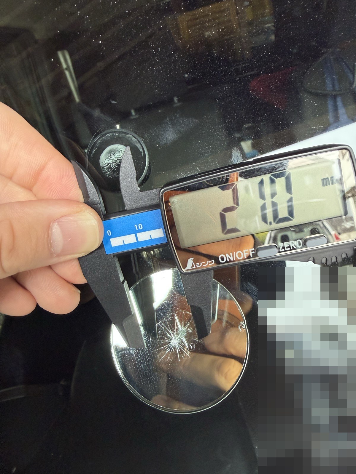 ジムニーJB64のフロントガラスの飛び石をノギスで測り21.0mmと表示されている施工前の写真
